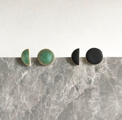 Semi circle shaped, ceramic stud earrings with black or green glaze.